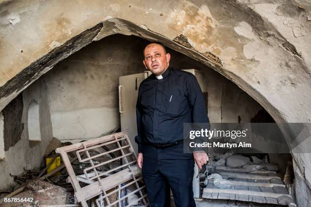 Chaldean Catholic Father Thadet inside his family home - damaged and burned by Islamic State militants - in Karamles, a Christian town in northern...