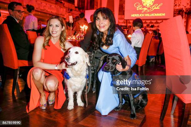 German presenter Jule Goelsdorf and German singer Dunja Rajter with assistance dogs during the 8th VITA Charity Gala on October 28, 2017 in...