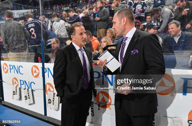 Head Coach John Tortorella of the Columbus Blue Jackets and Assistant Coach Brad Larsen of the Columbus Blue Jackets talk on the bench before a game...