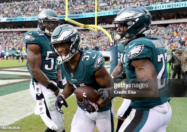 Jalen Mills of the Philadelphia Eagles is congratulated by teammates Nigel Bradham and Malcolm Jenkins after Mills picked off a pass from C.J....