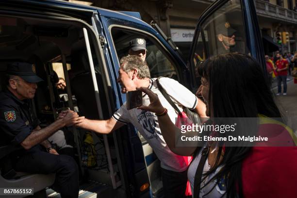 Protesters greet a police officer during a pro-unity demonstration on October 29, 2017 in Barcelona, Spain. Thousands of pro-unity protesters have...