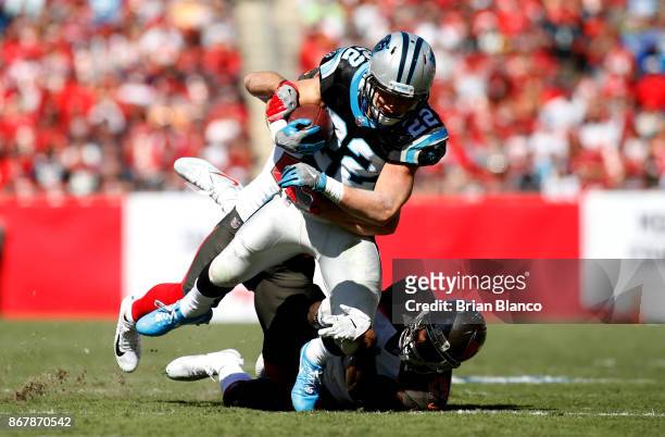 Running back Christian McCaffrey of the Carolina Panthers is brought down by free safety Chris Conte of the Tampa Bay Buccaneers and cornerback Ryan...