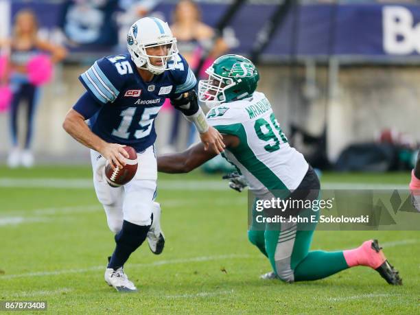 Ricky Ray of the Toronto Argonauts avoids a tackle by Ese Mrabure of the Saskatchewan Roughriders during a game at BMO field on October 7, 2017 in...