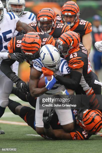 Carlos Dunlap, Vontaze Burfict and George Iloka of the Cincinnati Bengals tackle Frank Gore of the Indianapolis Colts during their game at Paul Brown...
