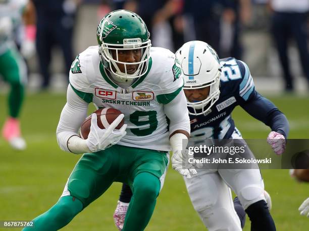 Duron Carter of the Saskatchewan Roughriders gains yards after a catch as Qudarius Ford of the Toronto Argonauts closes in during a game at BMO field...