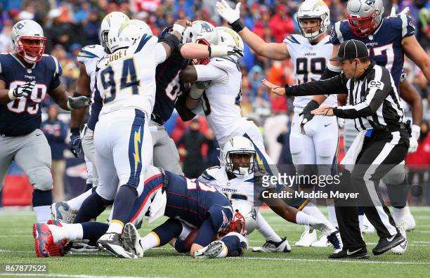 Players argue after Tom Brady of the New England Patriots is tackled by Desmond King of the Los Angeles Chargers during the third quarter of a game...