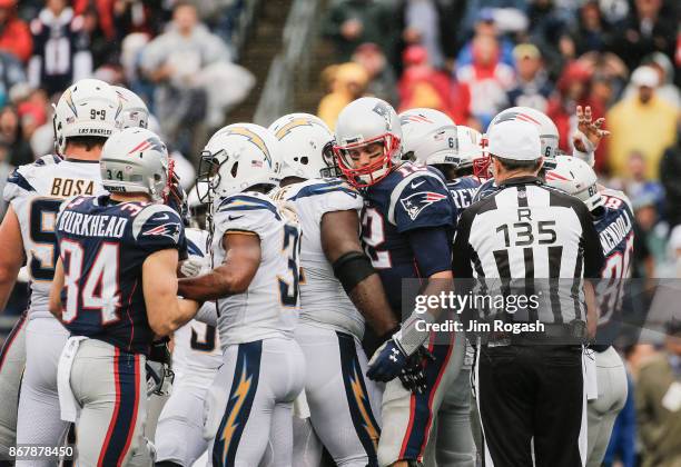 Players argue after Tom Brady of the New England Patriots is tackled by Desmond King of the Los Angeles Chargers during the third quarter of a game...