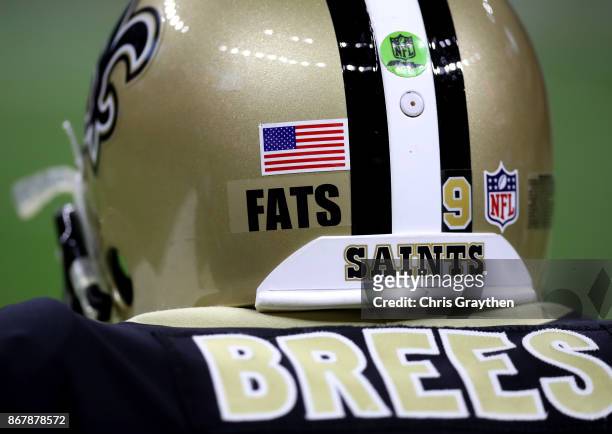 Drew Brees of the New Orleans Saints wears a sticker honoring musician "Fats" Domino Jr. Who passed away early last week during a game against the...