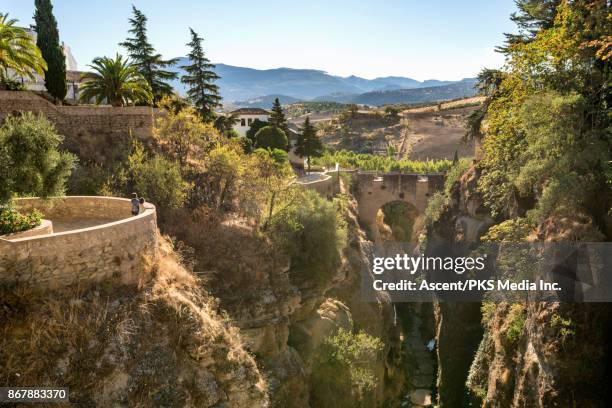 women look across village and gorge from stone wall - renda stock-fotos und bilder