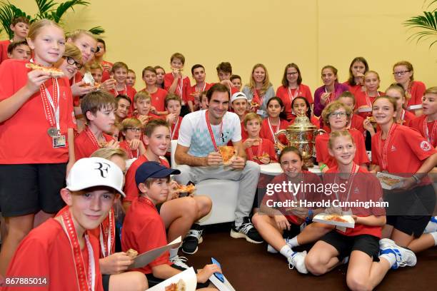 Roger Federer of Switzerland celebrates his victory with the tournament ball boys during the pizza party following the final match of the Swiss...
