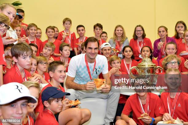 Roger Federer of Switzerland celebrates his victory with the tournament ball boys during the pizza party following the final match of the Swiss...