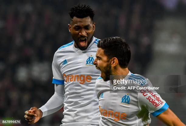 Marseille's French midfielder Morgan Sanson celebrates after scoring a goal with Marseille's Cameroonian midfielder Andre Zambo Anguissa during the...