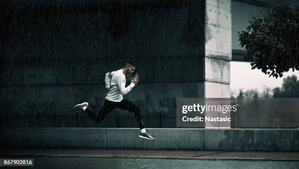 ejecutar tarde - man running city fotografías e imágenes de stock