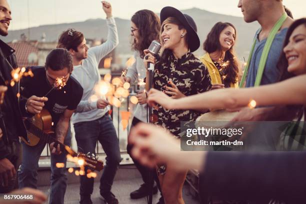friends celebrating new year on rooftop party - individual event stock pictures, royalty-free photos & images
