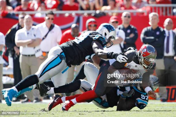 Jameis Winston of the Tampa Bay Buccaneers gets sacked by Mario Addison and Kawann Short of the Carolina Panthers in the third quarter of a game at...