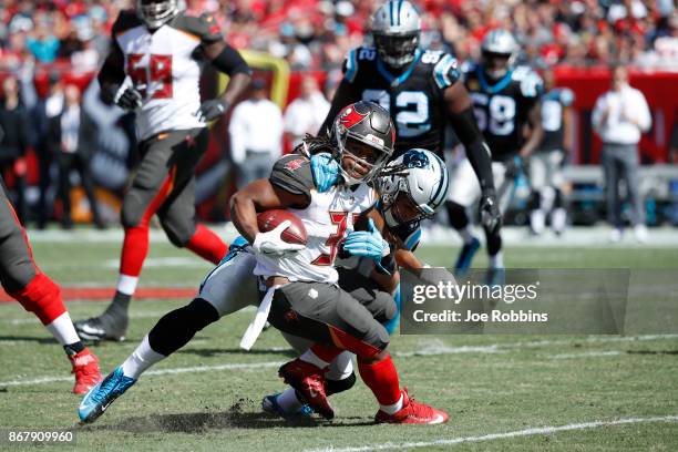 Jacquizz Rodgers of the Tampa Bay Buccaneers gets tackled after a catch by Luke Kuechly of the Carolina Panthers in the first quarter of a game at...