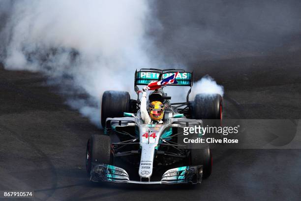 Lewis Hamilton of Great Britain and Mercedes GP celebrates with donuts on track after winning his fourth F1 World Drivers Championship during the...