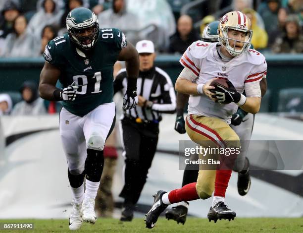 Beathard of the San Francisco 49ers scrambles with the ball as Fletcher Cox of the Philadelphia Eagles defends in the second half on October 29, 2017...