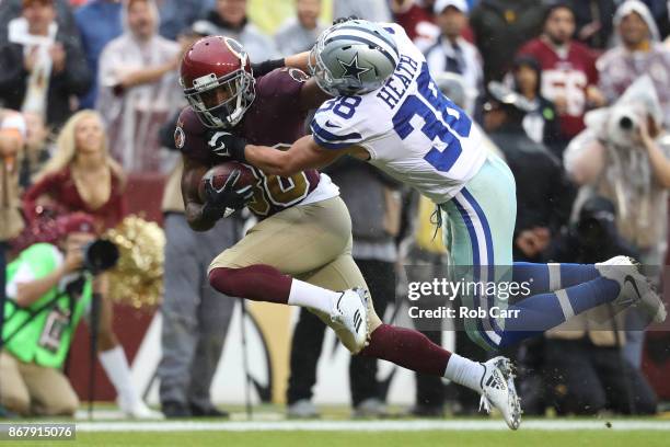 Wide receiver Jamison Crowder of the Washington Redskins stiff arms strong safety Jeff Heath of the Dallas Cowboys during the first quarter at FedEx...