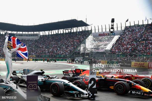Mercedes' British driver Lewis Hamilton celebrates after winning his fourth Formula One world title despite finishing the Mexican Grand Prix in ninth...