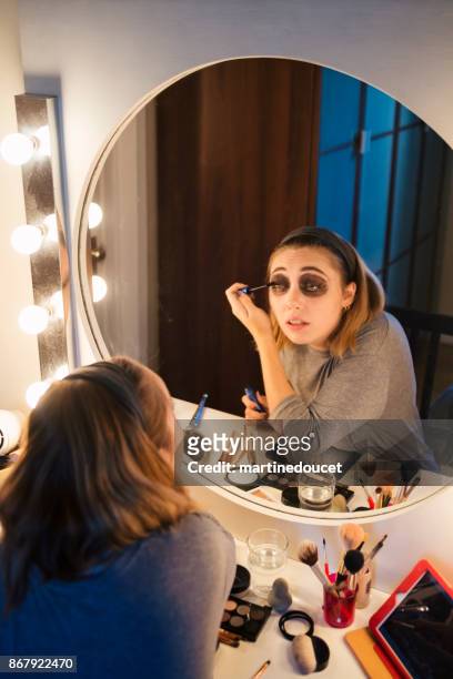 junge frau, die nach einem make-up tutorial in den sozialen medien zu hause - halloween makeup stock-fotos und bilder