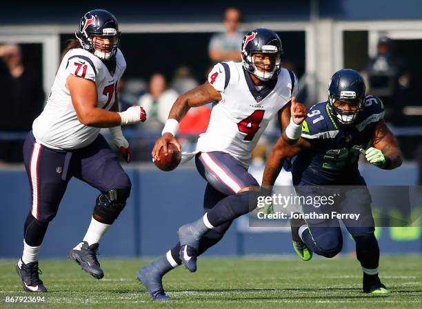 Quarterback Deshaun Watson of the Houston Texans escapes defensive tackle Sheldon Richardson of the Seattle Seahawks during the first half at...