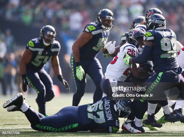 Running back Lamar Miller of the Houston Texans is taken down by tackle Tyrus Thompson of the Seattle Seahawks and Nazair Jones during the second...