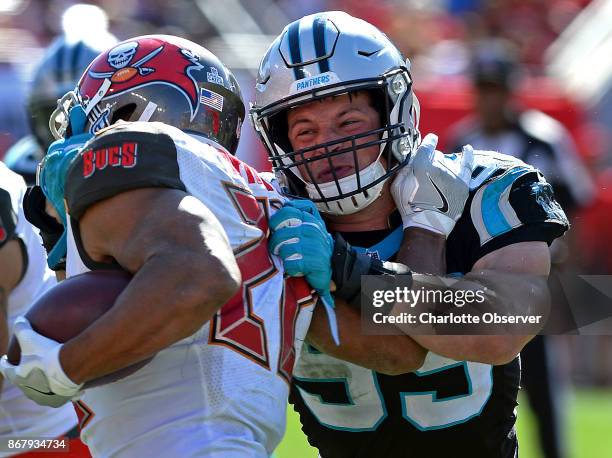 Carolina Panthers linebacker Luke Kuechly, right, makes the tackle on Tampa Bay Buccaneers running back Doug Martin, left, during fourth quarter...