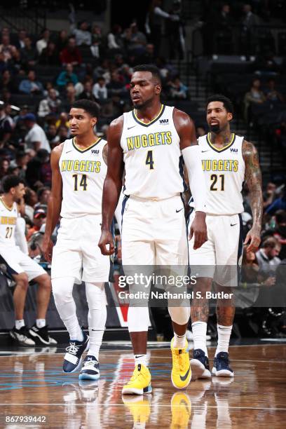 Gary Harris of the Denver Nuggets, Paul Millsap of the Denver Nuggets, and Wilson Chandler of the Denver Nuggets look on during the game against the...