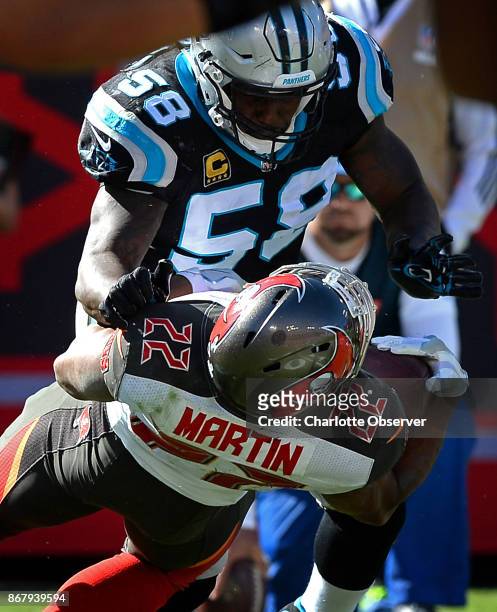 Carolina Panthers linebacker Thomas Davis makes a hard tackle on Tampa Bay Buccaneers running back Doug Martin during third quarter action on Sunday,...