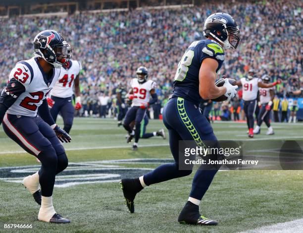 Tight end Jimmy Graham of the Seattle Seahawks pulls in a touchdown against safety Kurtis Drummond of the Houston Texans during the fourth quarter of...
