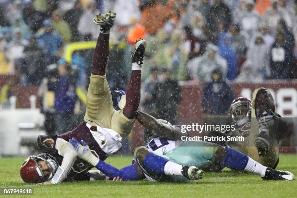 Quarterback Kirk Cousins of the Washington Redskins gets hit by defensive end Demarcus Lawrence of the Dallas Cowboys during the fourth quarter at...