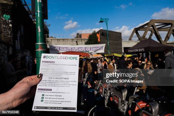 Members of Sisters Uncut deploy a banner in Brick Lane to protest the closing of Hopetown Hostel by the Tower Hamlets council. Hopetown is one of the...