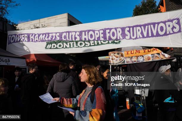 Members of Sisters Uncut deploy a banner in Brick Lane to protest the closing of Hopetown Hostel by the Tower Hamlets council. Hopetown is one of the...