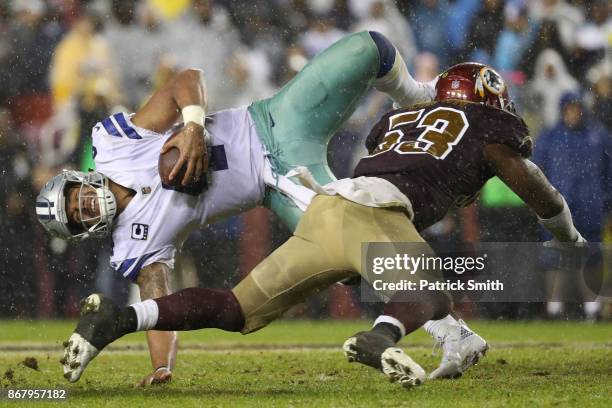 Quarterback Dak Prescott of the Dallas Cowboys is hit by inside linebacker Zach Brown of the Washington Redskins during the fourth quarter at FedEx...