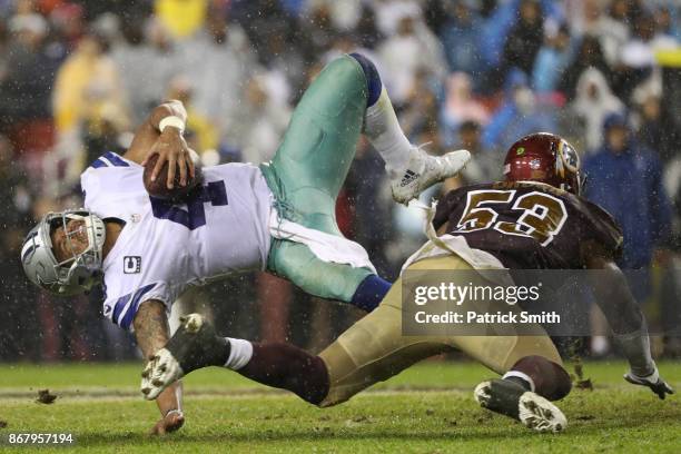 Quarterback Dak Prescott of the Dallas Cowboys is hit by inside linebacker Zach Brown of the Washington Redskins during the fourth quarter at FedEx...