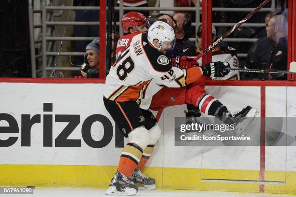 Anaheim Ducks Winger Logan Shaw checks Carolina Hurricanes Winger Janne Kuokkanen into the boards during a game between the Anaheim Ducks and the...