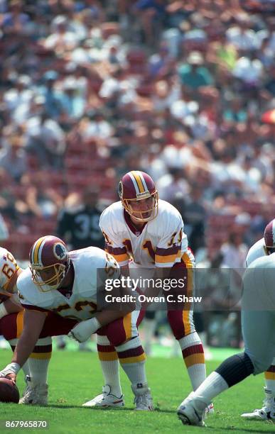 Mark Rypien of the Washington Redskins takes the snap against the Los Angeles Raiders at the Coliseum circa 1992 in Los Angeles,California.