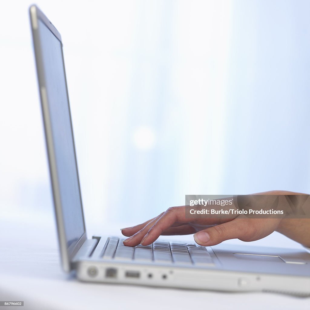 Hand on laptop computer keyboard