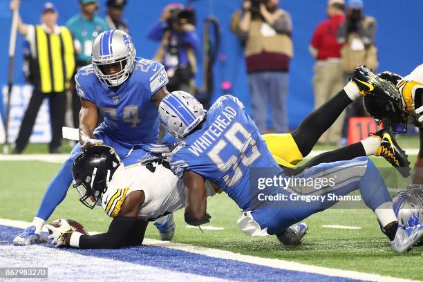 Running back Le'Veon Bell of the Pittsburgh Steelers dives over the goal line for a touchdown against cornerback Nevin Lawson of the Detroit Lions...