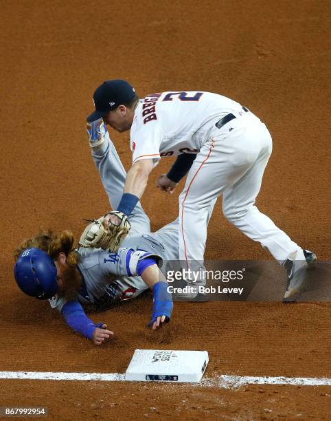 Alex Bregman of the Houston Astros tags out Justin Turner of the Los Angeles Dodgers at third base during the seventh inning in game five of the 2017...