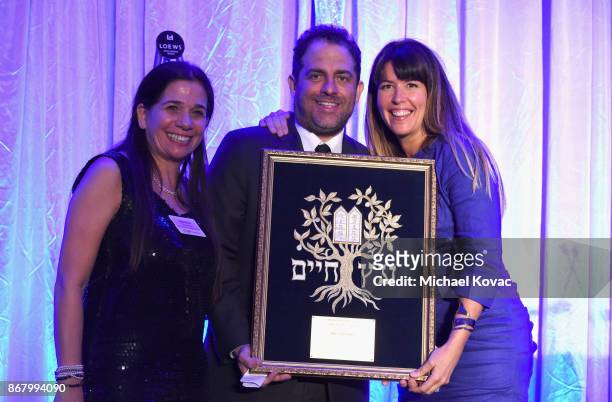 Honoree Brett Ratner accepts the Tree of Life Award from Patty Jenkins and Sharon Freedman onstage during the Jewish National Fund Los Angeles Tree...