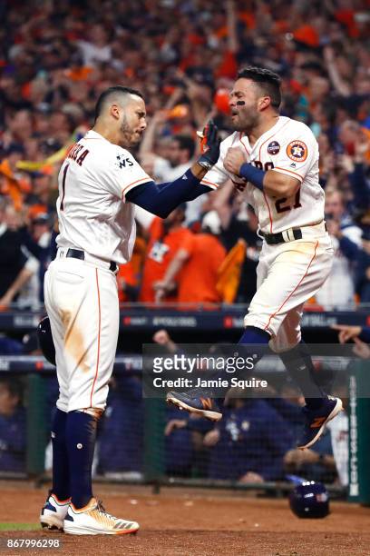Carlos Correa of the Houston Astros celebrates with Jose Altuve after hitting a two-run home run during the seventh inning against the Los Angeles...