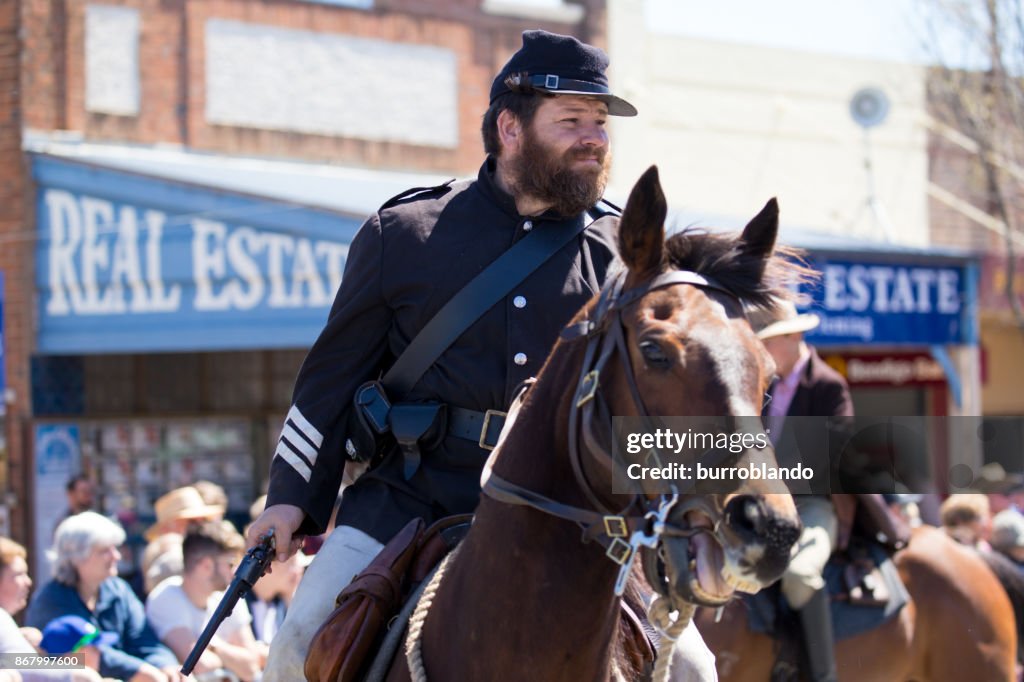 Bushrangers ride horse through the main street of town