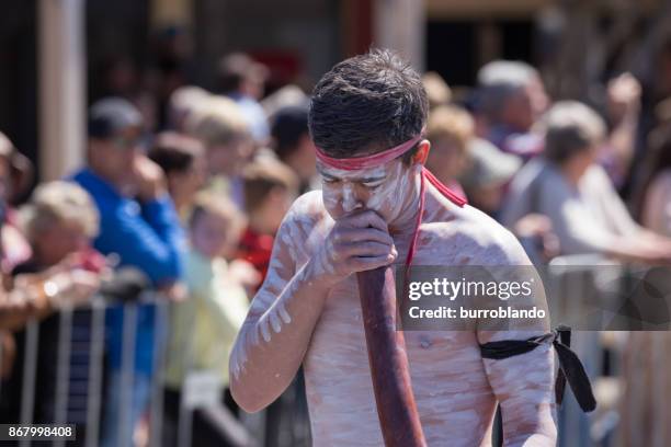 aborigines mann in traditioneller kleidung und farbe spielt eine didgereedoo während der boorowa irische woolfest - armband stock-fotos und bilder