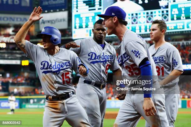 Austin Barnes of the Los Angeles Dodgers celebrates with Yasiel Puig, Cody Bellinger and Joc Pederson after scoring on a single during the ninth...