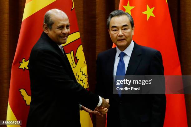 Chinese Foreign Minister Wang Yi and Sri Lanka's Foreign Minister Tilak Marapana shake hands before their meeting at the Ministry of Foreign Affairs...