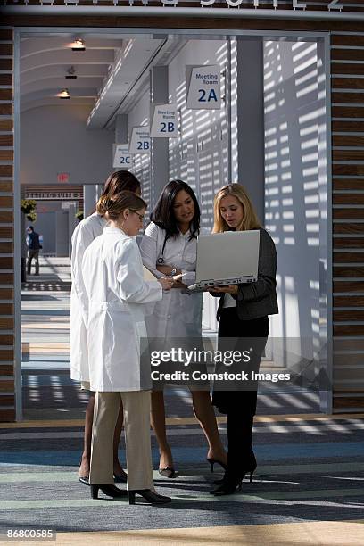 doctors talking over laptop computer - mind over matter stock pictures, royalty-free photos & images