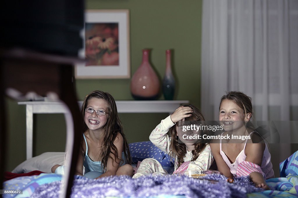 Girls watching television and laughing