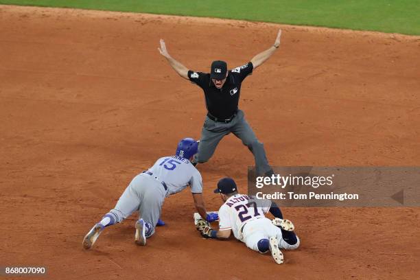 Austin Barnes of the Los Angeles Dodgers slides safely in to second base with a double as Jose Altuve of the Houston Astros attempts the tag during...
